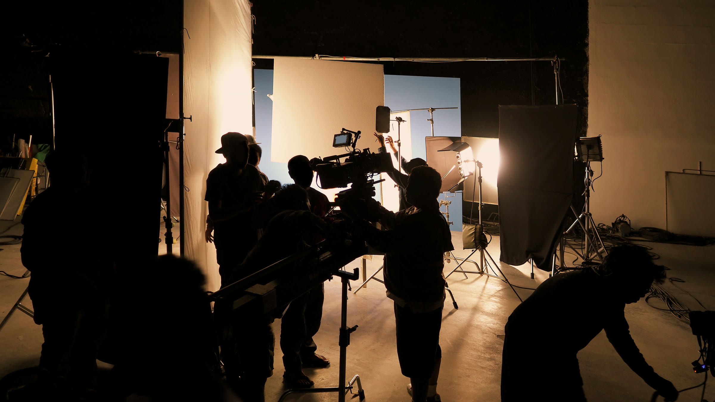 Film-Crew bei einem Videodreh im Studio — Kamera, Scheinwerfer und Team hinter den Kulissen